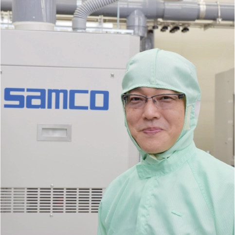 Dr. Satoshi Iwamoto in clean wear in front of Samco system (University of Tokyo)