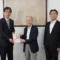 (Left) Yasuyuki Oze, Secretary General of the Kyoto Prefectural Branch of the Japanese Red Cross Society receives donation envelope from Osamu Tsuji, Founder and CEO of Samco Inc.; and Tsukasa Kawabe, President and COO of Samco Inc.